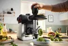 A person is using a food processor to make food in a kitchen setting. Náhled obrázku produktu