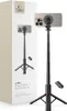 A product shot of a black selfie stick with a tripod base, a smartphone attached, and a remote control, next to its packaging. Produktbild-Vorschau