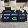 A modern living room scene featuring a black high-gloss coffee table with integrated LED lighting, a laptop, and decorative items. Náhled obrázku produktu