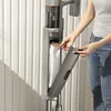 A person is shown interacting with a vacuum cleaner, specifically inserting or removing a dust bag. Produktbild-Vorschau