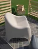An outdoor setting with a beige chair on a rug, surrounded by wooden fences and grass. Produktbild-Vorschau