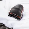 A close-up shot of a black Remington hair clipper resting on a white towel. Náhled obrázku produktu
