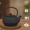 A black cast iron teapot sits on a wooden coaster, with decorative icons on the right side of the image. Podgląd zdjęcia produktu