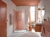 A modern bathroom with pink tiled shower and orange accents. Anteprima dell’immagine prodotto