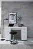 A white desk with a laptop, a stool, and decorative items against a concrete wall. Produktbild-Vorschau
