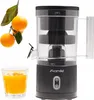 A black electric citrus juicer is shown next to a glass of orange juice and a branch with oranges. Produktbild-Vorschau