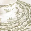 A close-up view of a stack of white plates with a green floral pattern. Produktbild-Vorschau