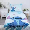 A bed with a Lilo and Stitch themed duvet cover and pillowcase, set against a white and light gray background with a bedside table and lamp. Produktbild-Vorschau