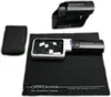 A set of optical tools including a magnifying glass, a protective case, and a cleaning cloth, laid out on a black surface. Produktbild-Vorschau