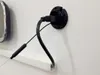 A close-up of a black cable plugged into a black circular mount on a white wall. Produktbild-Vorschau