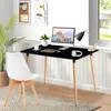 A modern home office setup with a black desk, white chair, computer, and plant. Voir les images du produit