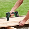 A person is using a cordless drill to screw into a wooden plank outdoors. Náhled obrázku produktu
