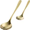 Two gold spoons on a white background. Anteprima dell’immagine prodotto