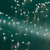 Close-up of coiled LED string lights on a teal background. Produktbild-Vorschau