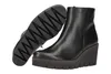 A black leather wedge boot is shown with its sole lifted to reveal the tread pattern. Produktbild-Vorschau