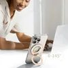 A woman is using a smartphone with a magnetic ring holder attached, while working on a laptop. Podgląd zdjęcia produktu