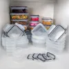 A collection of clear plastic food storage containers with black lids are neatly stacked and arranged on a white shelf. Náhľad obrázku produktu