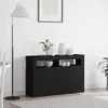 A black sideboard with decorative vases and bowls on top, placed in a room with a floor lamp and a rug.