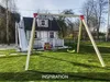 A backyard scene with a children's playhouse and swing set. Produktbild-Vorschau