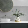 A modern bathroom vanity with a sink, faucet, and decorative items. Produktbild-Vorschau
