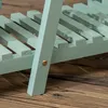 A close-up view of a light green wooden plant stand on a wooden floor. Produktbild-Vorschau