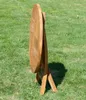 A folded wooden garden table is shown outdoors on a grassy lawn. Produktbild-Vorschau