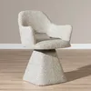 A single swivel chair with a textured taupe fabric and a geometric base, shown in a studio setting with a light gray wall and wooden floor.