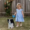 A young child walks a plush dog in a backyard. Anteprima dell’immagine prodotto