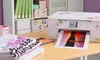 A Brother sublimation printer is printing a colorful image onto paper, with a stack of t-shirts and a mug on the desk. Náhled obrázku produktu