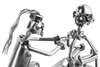 A close-up of two metal figures made from nuts and bolts, appearing to be a tattoo artist tattooing a client. Podgląd zdjęcia produktu