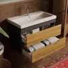 A modern bathroom vanity with a ceramic sink and open drawers revealing towels and toiletries. Produktbild-Vorschau