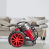 A vacuum cleaner in a living room setting with a sofa in the background. Voir les images du produit