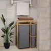 A bathroom scene with a laundry basket, towels, and a plant. Produktbild-Vorschau