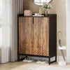 A shoe cabinet with two doors, decorated with a wood-like pattern and a geometric design at the bottom, is placed in a hallway next to a window with curtains and an umbrella stand. Produktbild-Vorschau