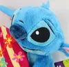 A close-up of a blue Stitch plush toy with a colorful floral pattern behind it. Anteprima dell’immagine prodotto