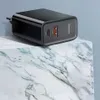 A black USB charger with two ports sits on a marble surface. Podgląd zdjęcia produktu