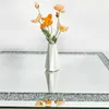 A white vase with orange and peach flowers sits on a mirrored surface with a crushed diamond inlay. Anteprima dell’immagine prodotto