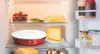 Inside a refrigerator, showing various food items and a red and white kitchen appliance. Podgląd zdjęcia produktu
