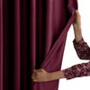 A hand is pulling back a dark red curtain. Produktbild-Vorschau