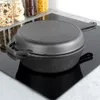 A cast iron pot with a lid sits on a black induction stovetop. Jars of food are visible in the background. Náhled obrázku produktu