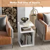 A white S-shaped side table with books and a bowl on it, placed next to a sofa and a fireplace with logs. Podgląd zdjęcia produktu