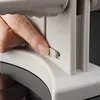 A close-up shot of a hand operating a lever on a kitchen appliance. Podgląd zdjęcia produktu