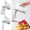 A collage of images showing a white Duronic hand mixer with various attachments, a hand holding the mixer, and a stack of waffles topped with berries and sauce. Produktbild-Vorschau