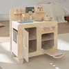 A wooden toy kitchen is set up on a rug in a room with a bed in the background. Anteprima dell’immagine prodotto