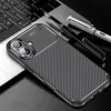 A smartphone case with a carbon fiber texture is placed on a laptop keyboard, with two pens nearby. Produktbild-Vorschau
