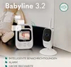 A baby monitor set with a parent unit and a camera unit, placed on a surface with a stuffed toy in the background. Overlay text highlights features. Anteprima dell’immagine prodotto