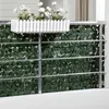 A balcony railing covered with a green leaf privacy screen, with a white planter box containing white flowers at the top. Anteprima dell’immagine prodotto