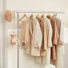 A collection of neutral-colored coats and accessories displayed on a clothing rack. Produktbild-Vorschau