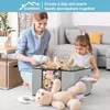 A mother and daughter are tidying up toys in a living room, placing them into a storage bin. Voir les images du produit