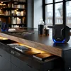 A modern desk setup with speakers, books, and decorative bottles. Náhľad obrázku produktu